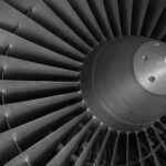 Detailed black and white image of an airplane turbine engine showcasing blades and craftsmanship.
